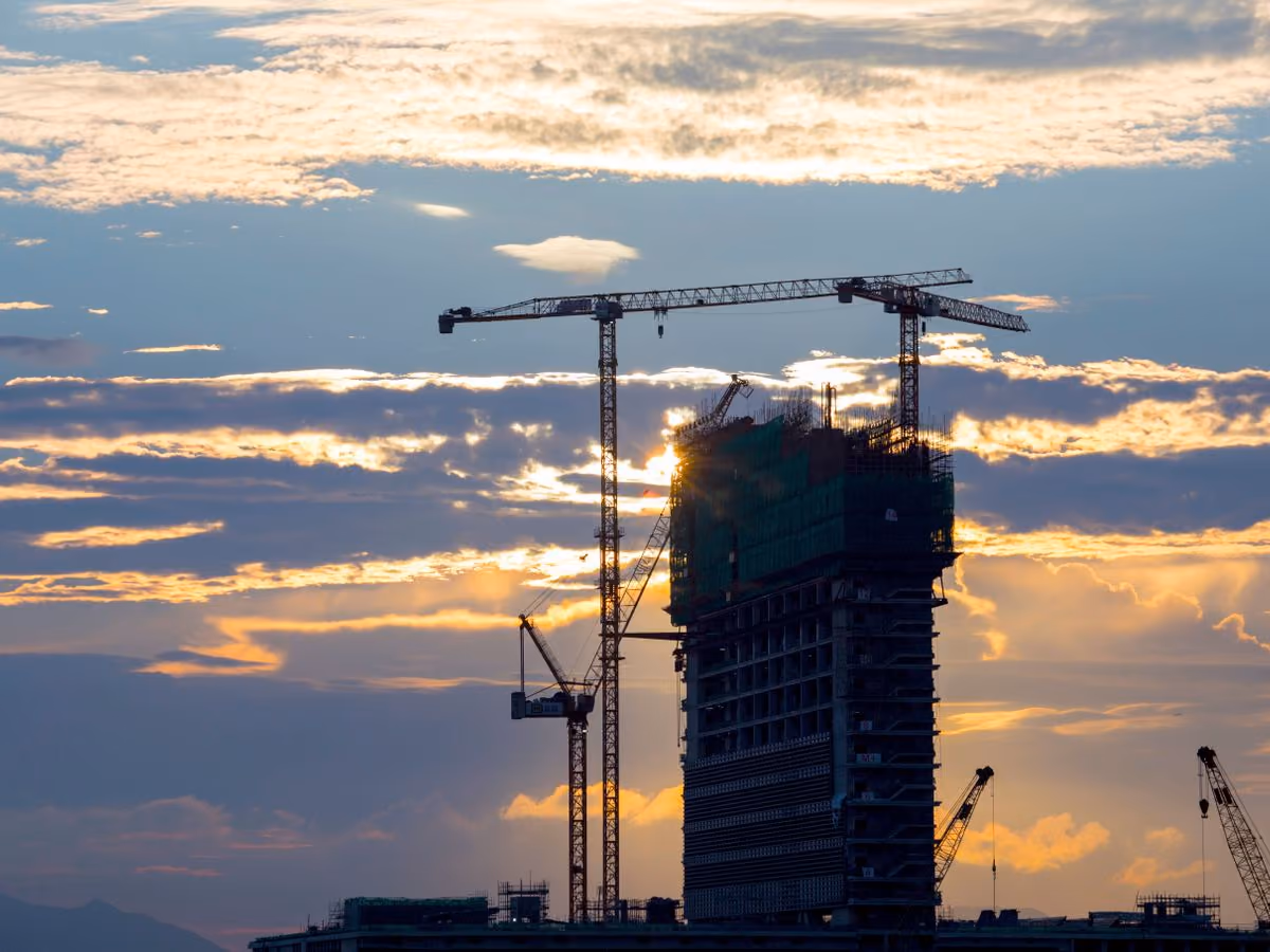 Unfinished concrete building with a tower crane